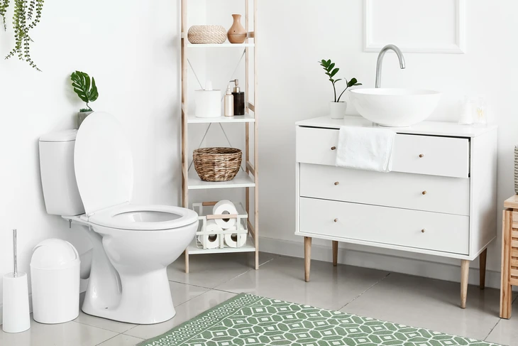 Belle salle de bains moderne et luxueuse avec armoire en bois clair, douche de plain-pied avec carrelage en marbre, robinets et quincaillerie noirs