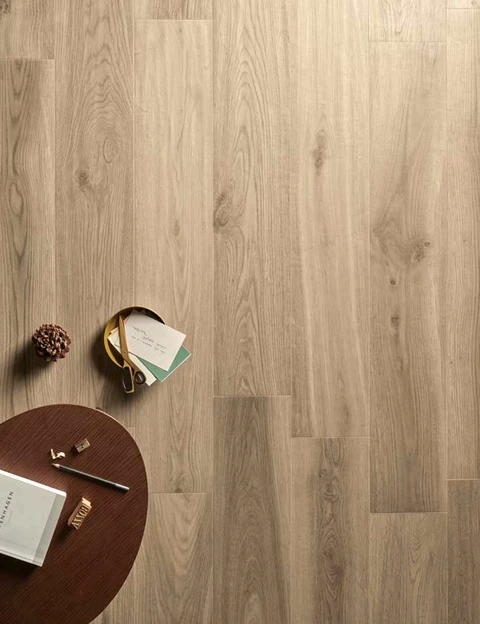 Scène d'intérieur avec sol en parquet chêne clair, table ronde en bois foncé avec documents, stylo et accessoires de bureau