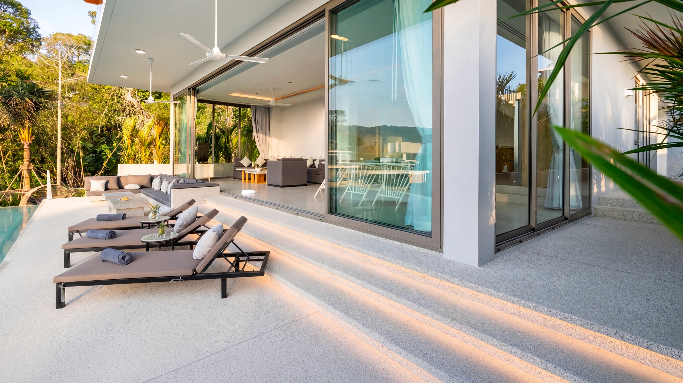 Terrasse extérieure avec mobilier en rotin naturel disposé sur carrelage gris
